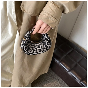 Detail of trendy leopard print mini crescent bag with golden metallic hardware and zipper