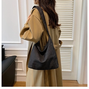Vue latérale du grand sac cabas en tweed gris foncé porté par un mannequin au style décontracté
