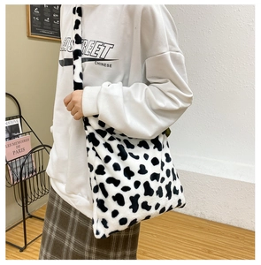 Detail of cow print plush crossbody bag showing its soft texture and large size