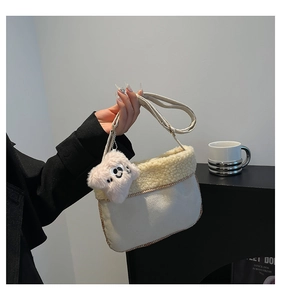 Detail of plush lamb wool patchwork crossbody bag with cute dog charm and wide strap