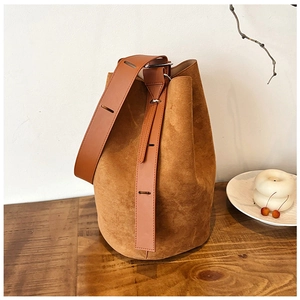 Close-up of vintage brown matte bucket bag with adjustable strap and silver buckles
