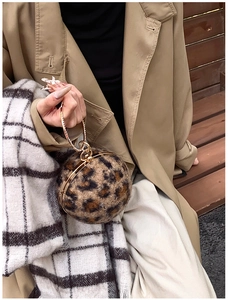 Détail d'un sac boule léopard en peluche avec poignée anneau dorée et chaîne