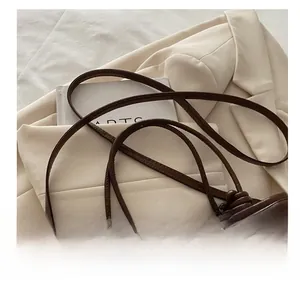 Detail view of dark brown vintage faux leather shoulder bag with stylish knotted strap design