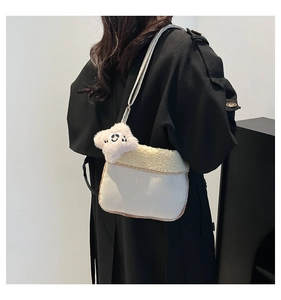 Detail of plush off-white crossbody bag with faux fur trim and star charm on model