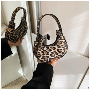 Detail view of leopard print crescent bag with golden metal buckle and sleek zip closure