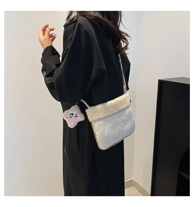 Detail view of white plush crossbody bag with cute panda charm and lamb wool flap