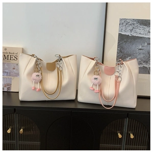 Detail of minimalist tote bags with soft faux leather texture and plush charms
