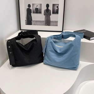 Grand sac hobo en jean noir et bleu avec bandoulière à œillets pour un look décontracté