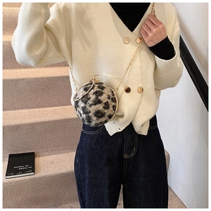 Détails d'un mini sac boule léopard en peluche avec anneau doré et bandoulière chaîne