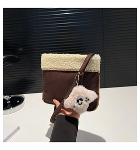 Detail of plush brown suede mini crossbody bag with shearling trim and cute charm