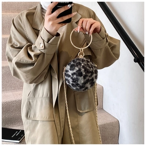 Détail du sac boule en peluche léopard avec poignée anneau doré et chaîne métal