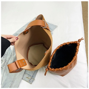 Detail view of brown faux suede bucket bag with a matching drawstring inner pouch