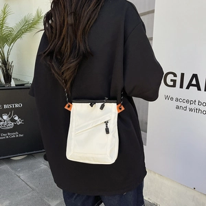 Close-up of cream nylon crossbody phone bag with orange stitching and rope strap