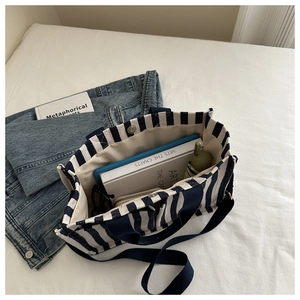 Detail view of large capacity striped canvas tote bag showing spacious interior and magnetic snap