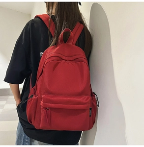 Detail shot of the large red casual backpack with front pocket and side bottle holders