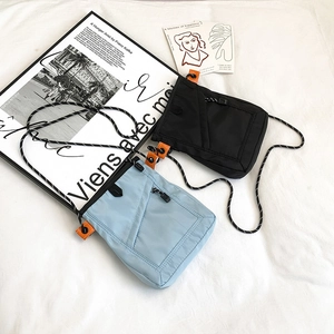 Detail view of water-resistant nylon crossbody bags with dual zippers and striped straps