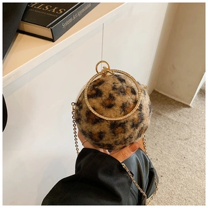 Détail du sac boule motif léopard avec poignée anneau dorée et bandoulière en chaîne