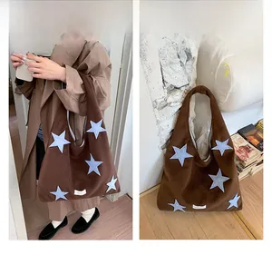 Detail of dark brown plush tote bag with light blue star embroidery and soft texture