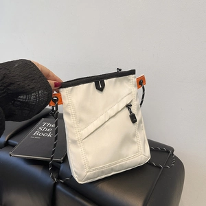 Detail view of small white nylon crossbody bag with orange accents and woven shoulder strap