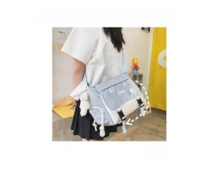 Detail showing blue and white canvas messenger bag with buckle and plush bear pendant