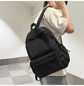 Detail view of durable black commuter backpack with spacious pockets and minimalist design