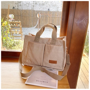 Light coffee corduroy tote bag showing large front pockets and adjustable strap