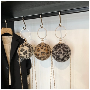 Détail de mini sacs boules en peluche léopard avec poignées anneau dorées et bandoulière chaîne