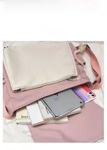 Pink and beige messenger bag showing internal storage for tablets and notebooks