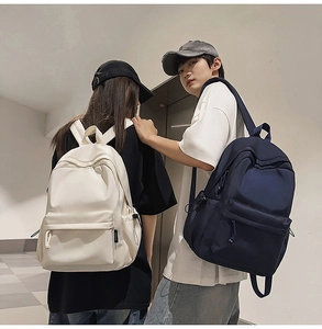 Couples wearing minimalist backpacks in beige and navy blue showing the side profile view