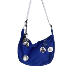 Blue nylon crescent messenger bag with badges and checkerboard charm for women