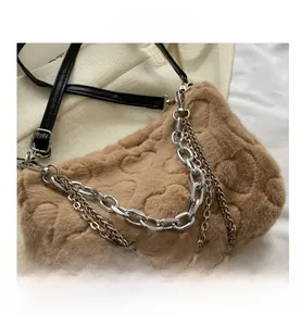 Vue détaillée du sac en peluche marron avec motif cœur et chaîne argentée