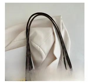 Nahaufnahme des bedruckten Shopper-Griffs mit Goldkette und Monogramm-Musterung