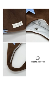 Detail of star embroidery plush tote bag showing magnetic buckle and brand label