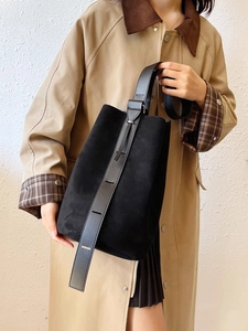Minimalist black matte leather bucket bag with wide adjustable shoulder strap