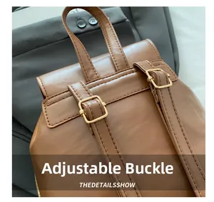Detail of adjustable golden metal buckle on brown faux leather backpack straps