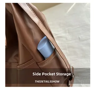 Detail view of the functional side pocket on a brown vintage faux leather backpack tote