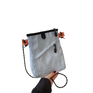 Gray canvas messenger bag with orange accents and rope strap for daily commuting