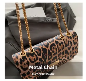 Detailed view of leopard print shoulder bag with elegant golden chain and metal eyelets