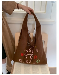 Detail of a brown plush tote bag featuring a cute wizard dog with star embroidery