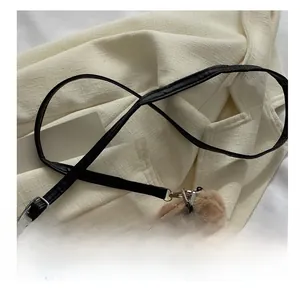 Détail du sac à bandoulière en peluche marron avec sangle noire et chaîne métal