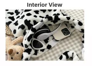 Detail view of cow print plush tote bag interior holding headphones and sunglasses