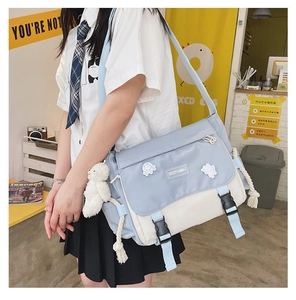 Detail of blue and white messenger bag with cute bear charm and buckles