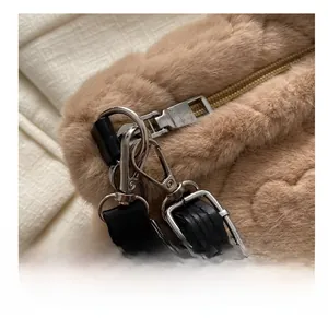 Détail de la fermeture éclair argentée et chaîne métallique sur un sac à main en peluche