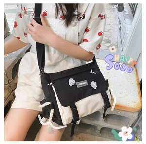 Detail shot of canvas messenger bag featuring cute astronaut badges and plush charm
