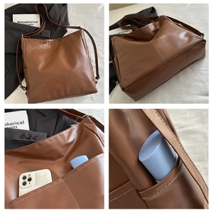 Detail of large brown leather tote bag showing side pocket storage and matte finish