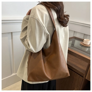Detailed close-up showing the caramel brown leather texture of the large tote shoulder bag