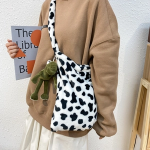 Cute cow print plush shoulder bag for women with green frog charm accessory