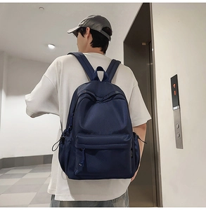 Side view of deep blue waterproof nylon backpack on model in modern office hallway