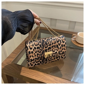 Detail of leopard print shoulder bag with gold chain strap and metallic buckle closure