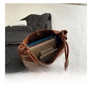 Detail showing the large capacity of a brown vintage tote bag with magnetic metal closure